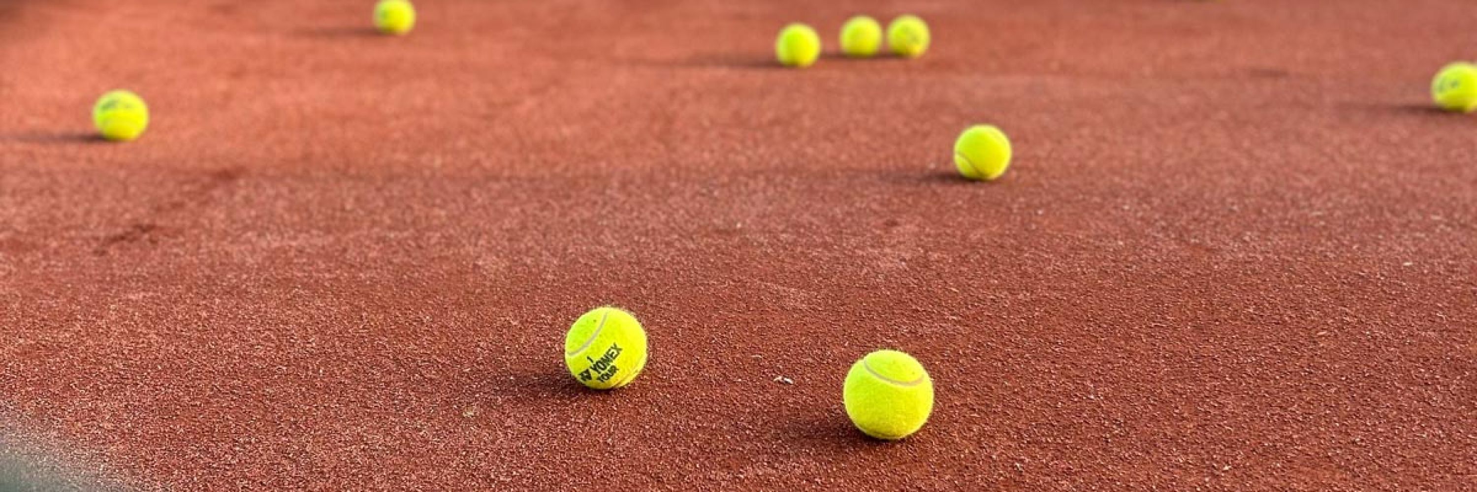 Tennisbälle liegen auf einem Tennisplatz